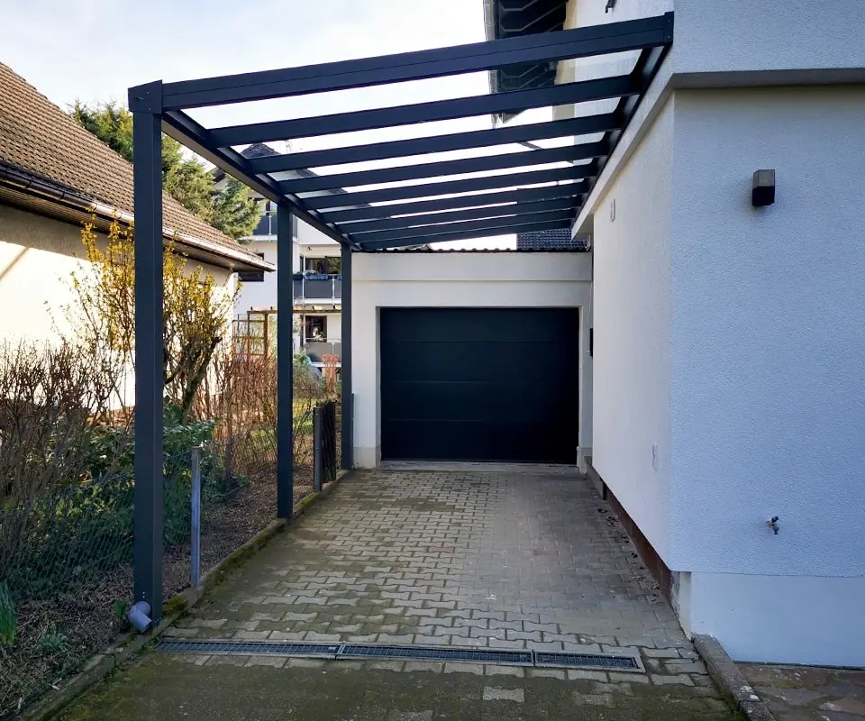 Anlehn-Carport aus Aluminium mit Stegplatten neben Garagentor – platzsparend in Köln
