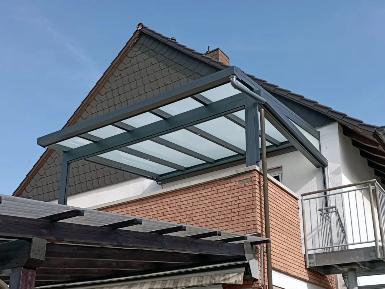 Balkonüberdachung Anthrazit mit Glasdach am Einfamilienhaus mit Satteldach