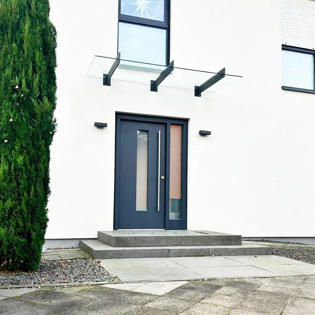 Glasvordach mit Dreifachträger an dunkelblauer Haustür in Overath