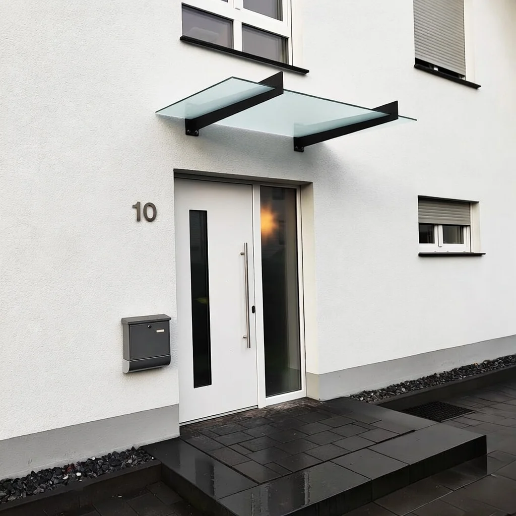 Glasvordach mit Milchglas und minimalistischem Wandhalter in Rösrath
