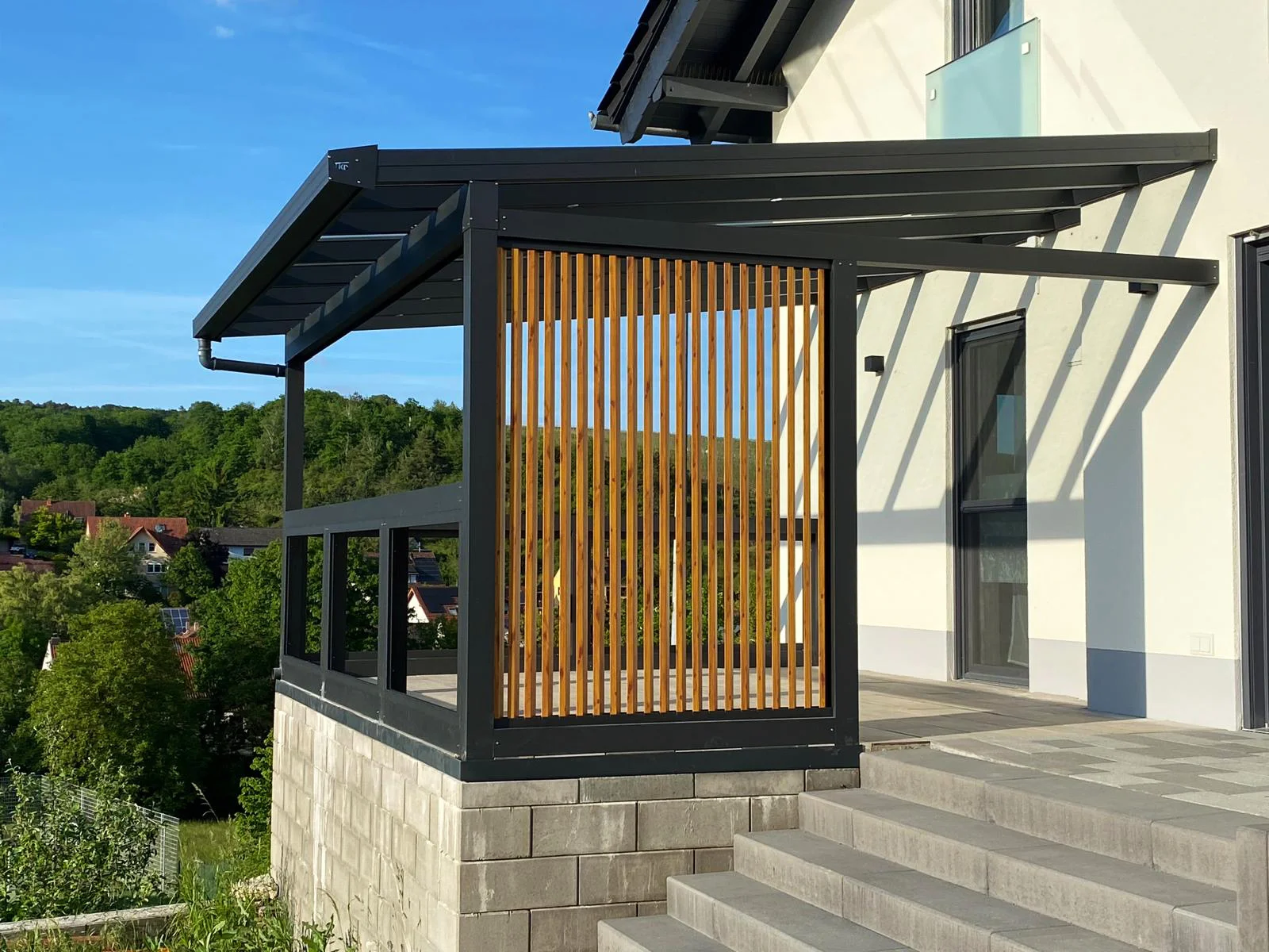 Terrassenüberdachung mit Sichtschutz aus Glas und Aluminium in Köln